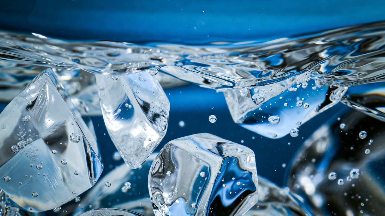 Ice cubes submerged in crystal clear cold blue water